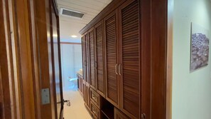 A hallway with wooden cabinets, a visible toilet, and a ceiling vent. - Cozy Penthouse Beach in Punta Cana, Apt 3 Bedrooms, 4 Bed-3 Bath-Pool-BBQ-AC (Punta Cana)