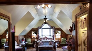An attic bedroom with a large bed, wooden flooring, a chandelier, and a view of the outside. - "The Love Nest" - Stunning Views overlooking the Shenandoah in Wine Country (Markham)