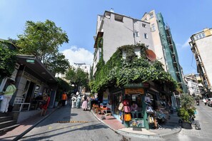 A street with shops, a café, and a building with a satellite dish. - Taksim Private Terrace Near Museum of Innocence (Istanbul)