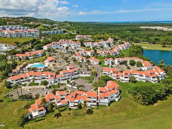 Ein Resort mit mehreren Gebäuden, einem Swimmingpool und einem See.
