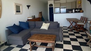 A living room with a gray sofa, a wooden coffee table, and a checkered floor. - Duplex T2 first line on the beach with parking Palavas/Carnon (Palavas-les-Flots)
