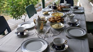 A table set for a meal with plates, bowls, and utensils. - Karin's B&B (Sisian)