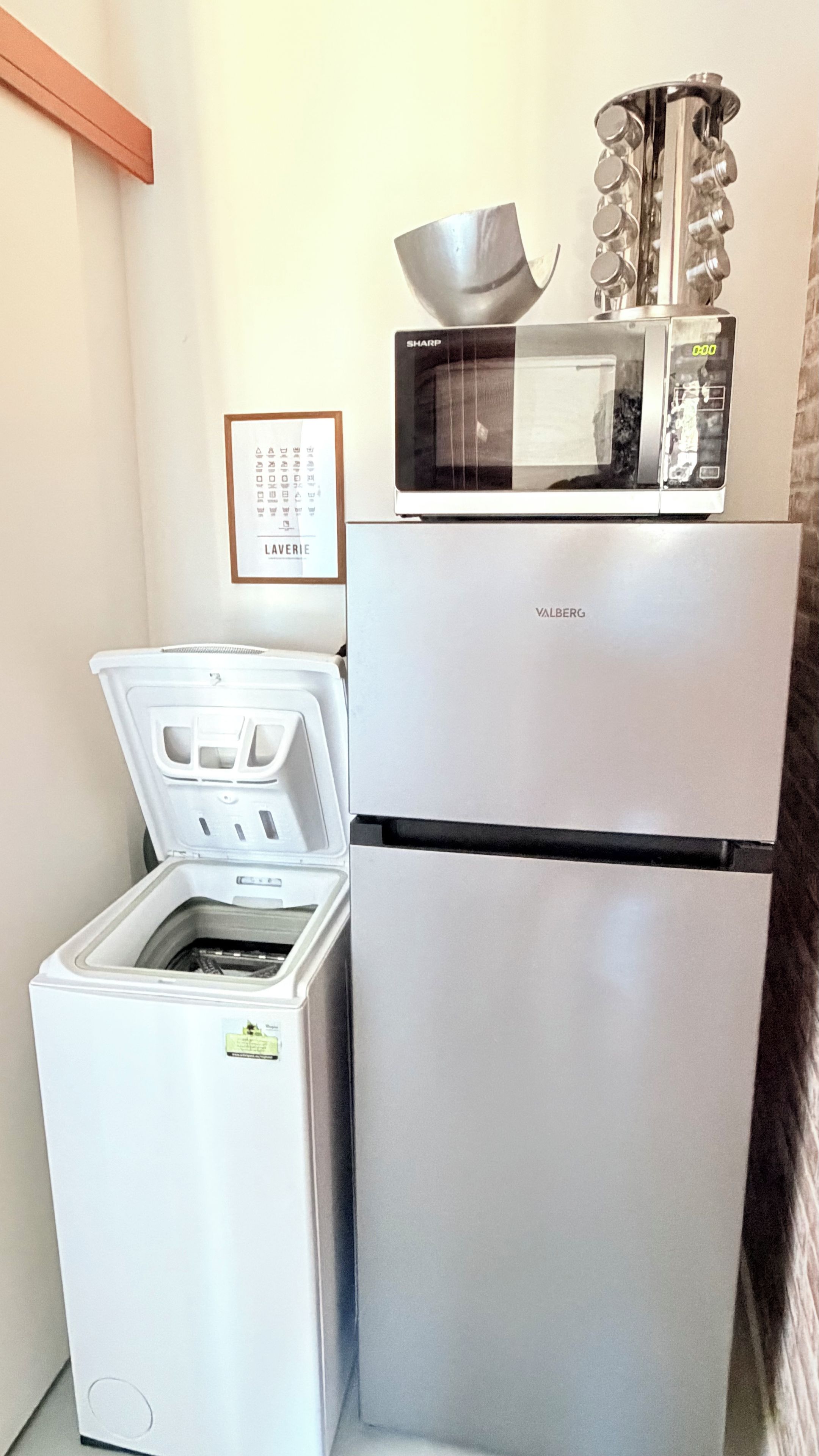 Una cocina compacta con un refrigerador blanco, un microondas y un lavavajillas.