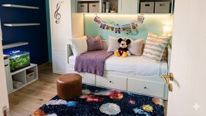 A cozy bedroom with a bed, a bookshelf, a desk, and a fish tank. - Family home with garden, trampoline and ideal location (Piolenc)