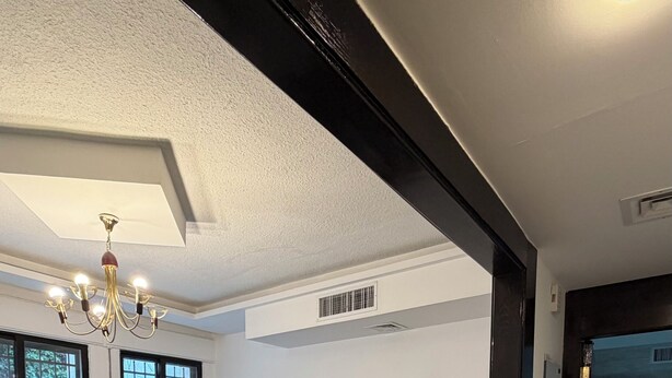 Una sala de estar moderna con un sofá modular, una pequeña mesa de centro y una araña.
