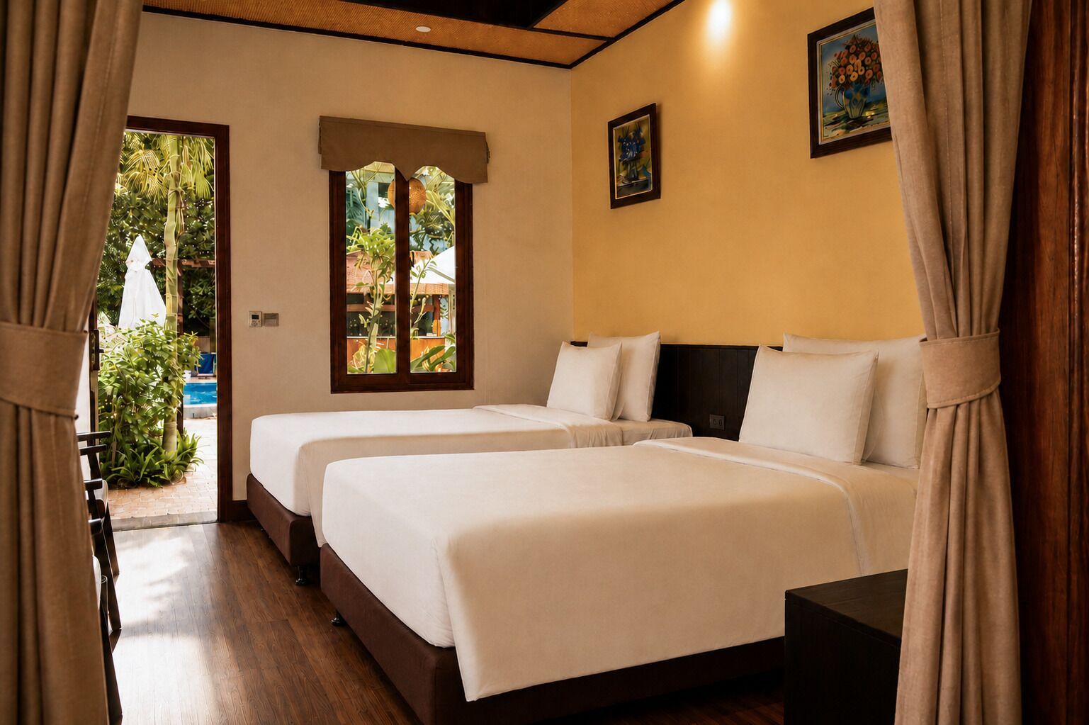 A hotel room with two beds, a window with a view of greenery, and a door leading to an outdoor area.