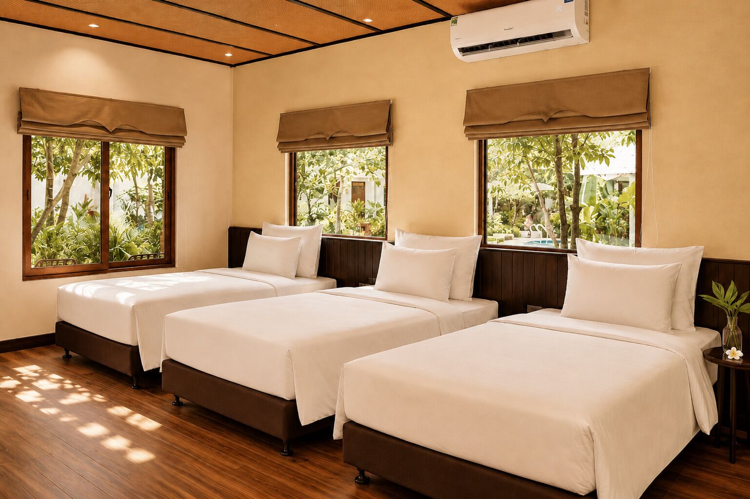 A hotel room with three beds, wooden flooring, and large windows with curtains.