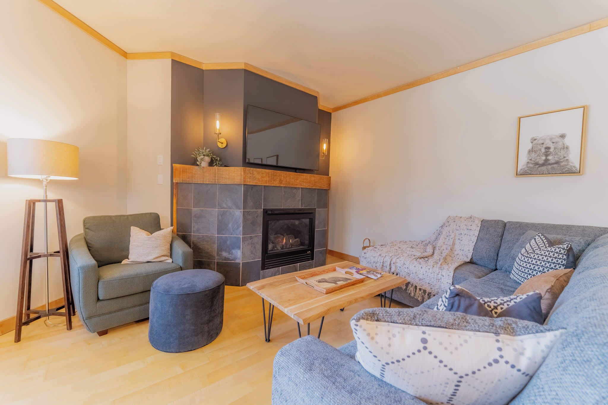 Ein Wohnzimmer mit Kamin, einer Couch, einem Couchtisch und einer Lampe.