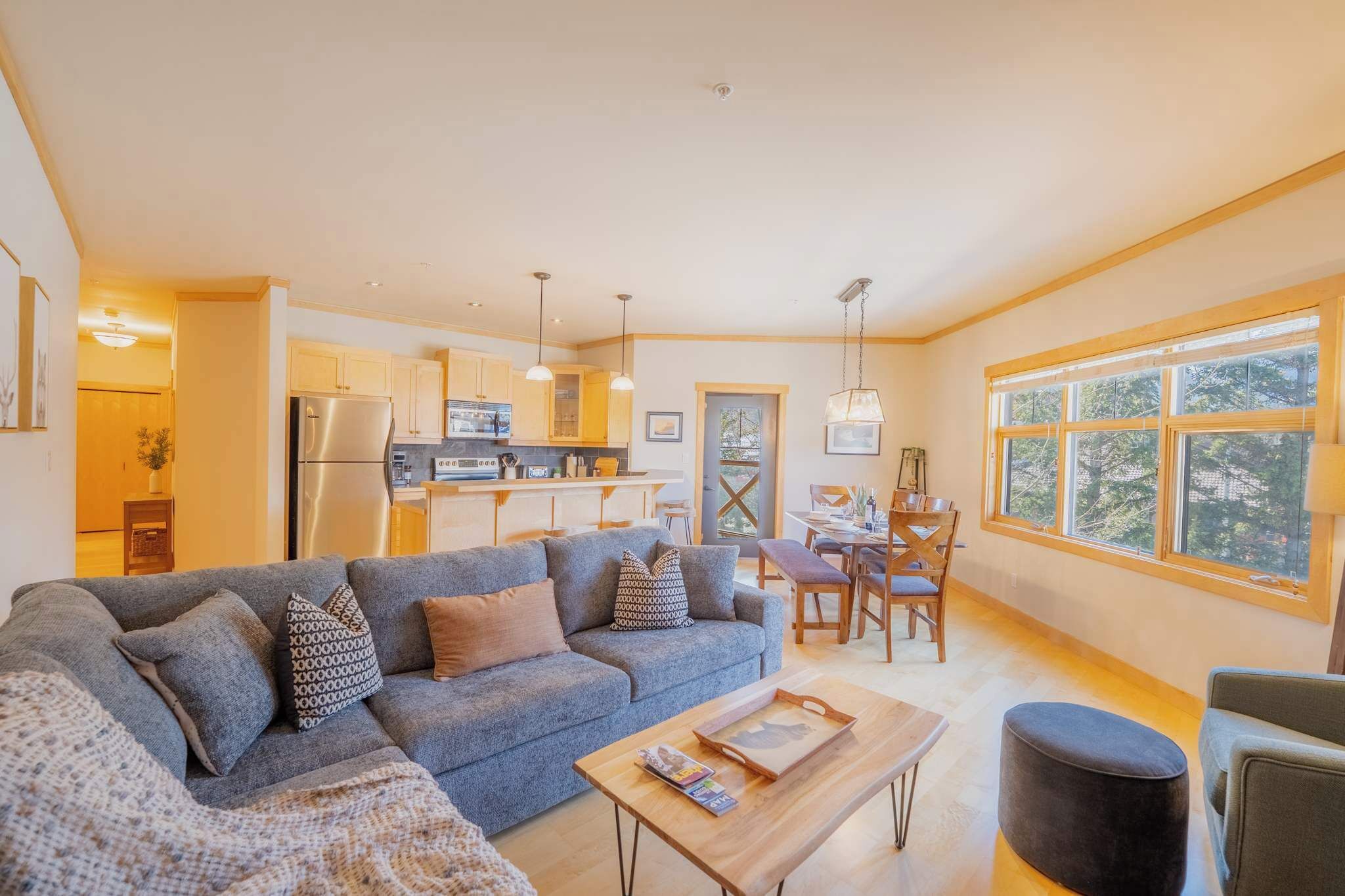 A modern living room with a sofa, coffee table, and dining area.