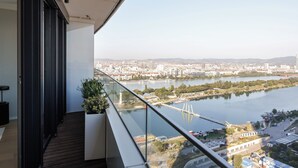 A balcony with a view of a river, cityscape, and a bridge. - Skyline Suite - Danube-View Balcony&Pool (Vienna)