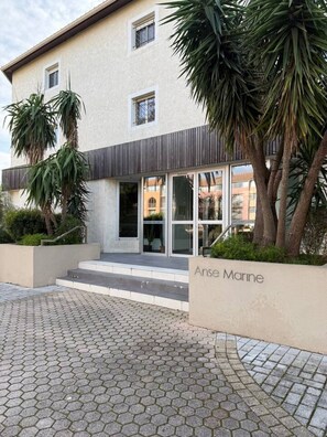 Un bâtiment moderne à la façade beige, doté de grandes fenêtres et d’une enseigne indiquant « Anse Marine ».