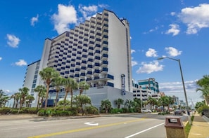 A hotel with a checkered facade, palm trees, and a clear blue sky. - Incredible Beach Villa 1bd/1ba Myrtle Beach (Myrtle Beach)