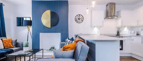 En moderne stue med sofa, sofabord og en blå væg.