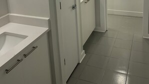 A bathroom with a white sink, a bathtub, and a door leading to another room. - Industrial Tech Loft in Atlanta (Atlanta)