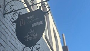 Un letrero con el nombre 'TANTE' y la fachada de un edificio.