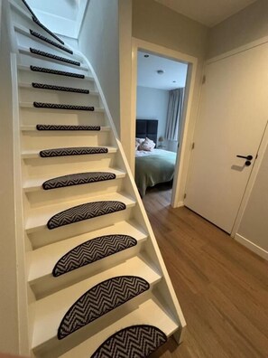 Een trap met versierde treden die naar een slaapkamer leidt.