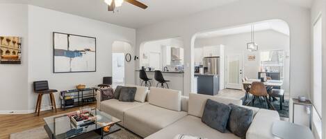 A modern living room with a sofa, coffee table, and ceiling fan.