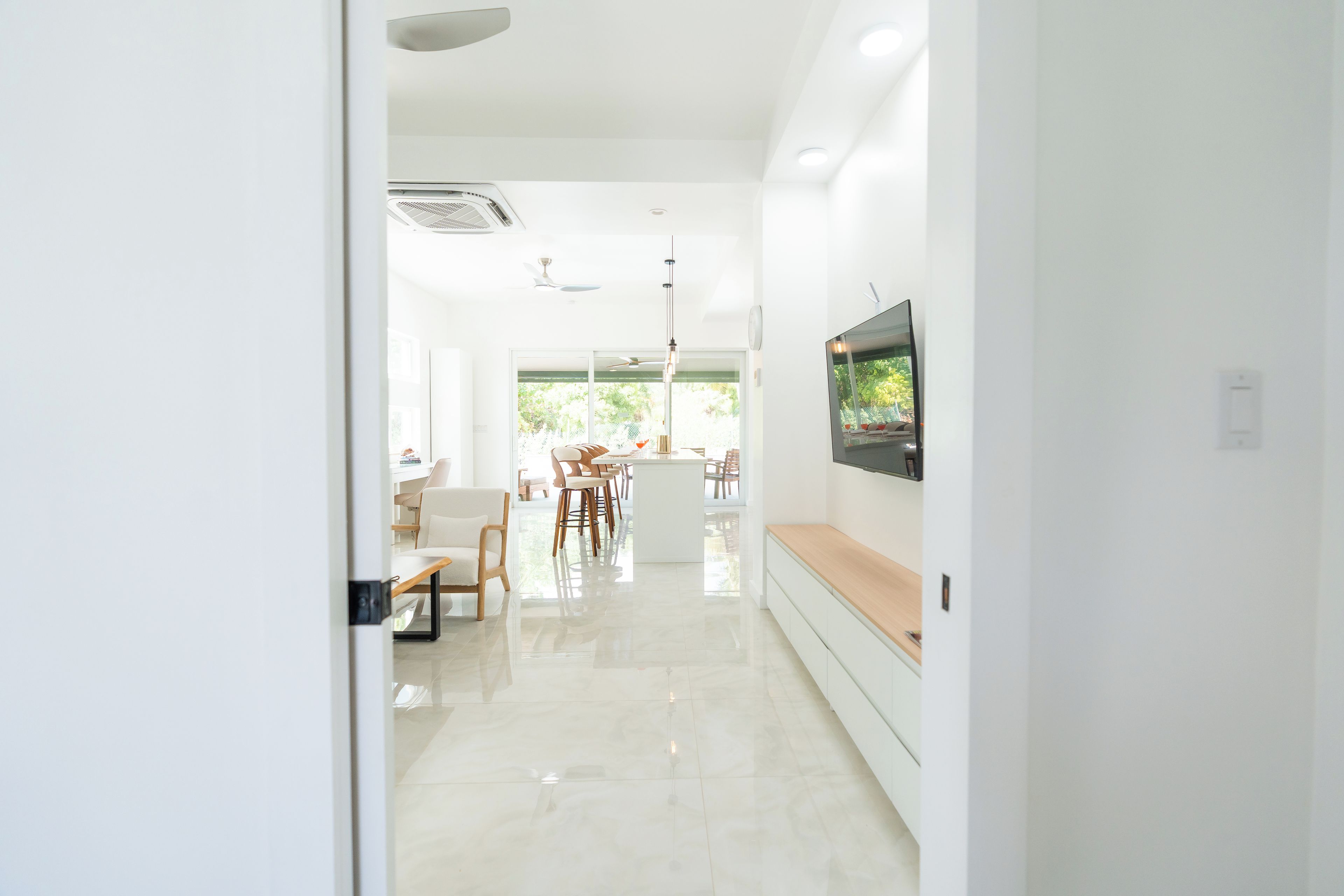 Ein modernes Interieur mit Küchenbereich, Essbereich und einem an der Wand befestigten Fernseher.