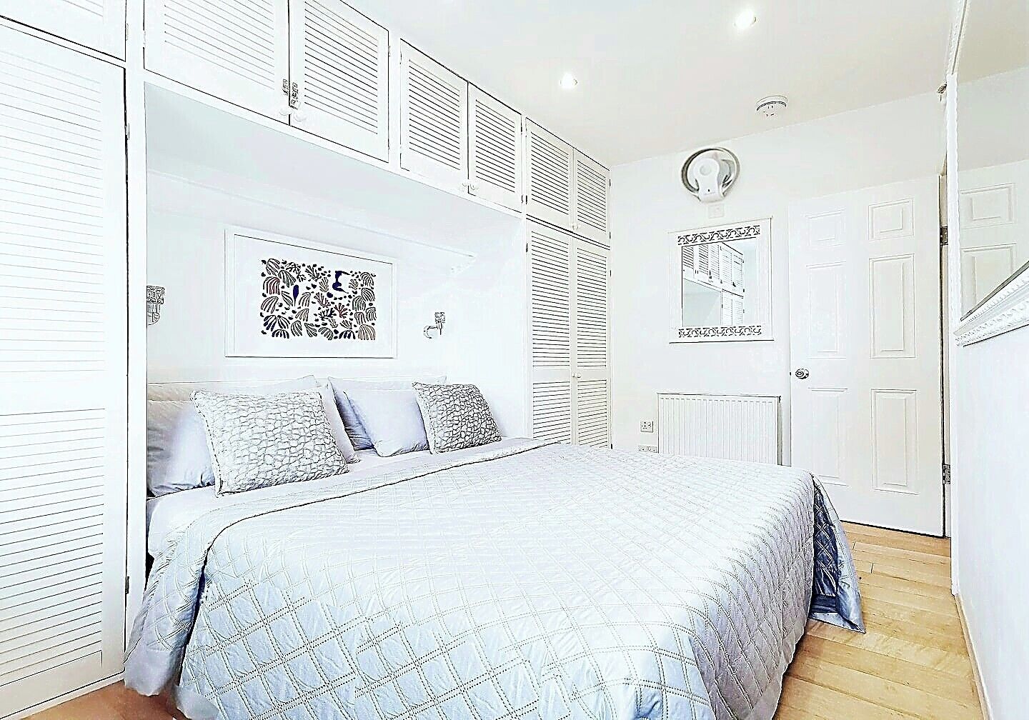 Een slaapkamer met een bed, een kast en een radiator.