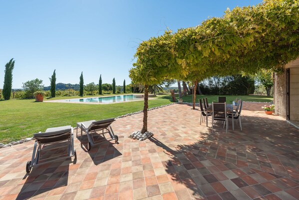A patio with outdoor furniture, a swimming pool, and a view of the landscape. - Wine Estate 20m Pool and Cinema (Pezenas)