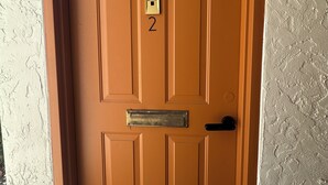 A brown door with a number '2' and a mail slot, set in a textured wall. - Hotel Style 1-bedroom in lovely Orlando with AC (Orlando)