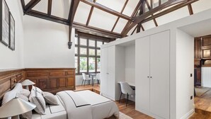 Quarto com cama, mesa de cabeceira e um guarda-roupa espaçoso.