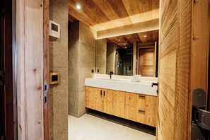 A modern bathroom with wooden cabinetry, a large mirror, and a built-in sink. - Modern Apartment Ski-in - Mont D'arbois With View (Megeve)