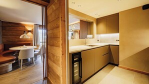 Een moderne keuken met houten details, een eethoek met een ronde tafel en stoelen, en een inbouwoven.
