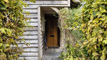 A wooden building with a door and a small step leading to it.