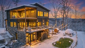 A multi-story lodge with a stone facade, a balcony, and a snow-covered landscape. - 2+m villa/NordicSpa/StargazingDome/Skylounge/Epic view/Pool/minigolf/Microevents (Sevierville)