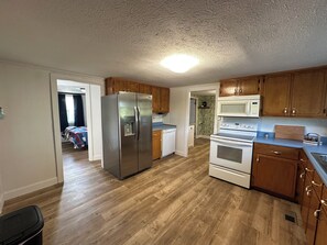 Una cocina con armarios de madera, un refrigerador de acero inoxidable, un microondas y un horno.