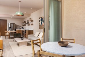 A modern living room with a round table, a sofa, and a dining area with chairs. - Las Arenas de Cabo one block from the beach (Cabo San Lucas)