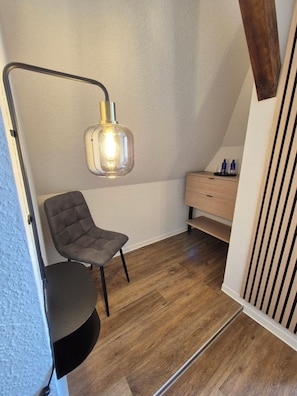 A room with a chair, a desk, a lamp, and a wooden floor. - Seehaus Miersdorf (Zeuthen)