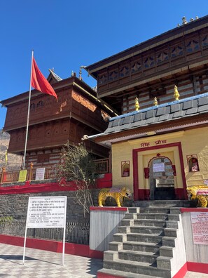 A traditional building with a red flag, a signboard, and a staircase leading to the entrance. - Your home away from home in mountains / 1-bedroom bed & breakfast (Shimla)