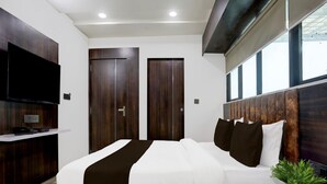 A modern bedroom with a large bed, built-in wardrobe, and a flat-screen TV. - Deluxenana Chiloda Near Airport (Gandhinagar)