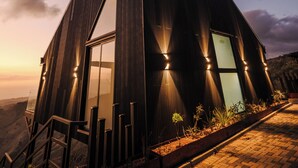 A modern building with a triangular roof, large windows, and a brick pathway leading to the entrance. - Cozy 2-bedroom villa in serene Monteverde with Pool and AC (Monteverde)
