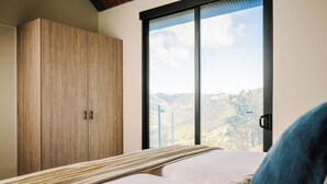 A bedroom with a bed, a large window, and a wardrobe. - Cozy 2-bedroom villa in serene Monteverde with Pool and AC (Monteverde)