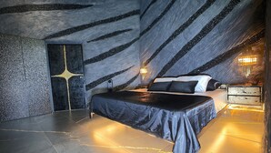 Ein Schlafzimmer mit einem Bett, einem Nachttisch und einer Wand mit einem einzigartigen Muster.