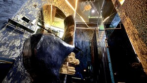 Ein rustikales Interieur mit freiliegenden Backsteinwänden, einer Steinwand und einem Metallgeländer.