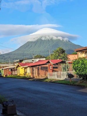 A street with houses, a mountain in the background, and a clear sky. - Sweet Townhouse, 5 min. walk to La Fortuna centro, AC, Mini Pool w Volcano View! (La Fortuna)