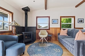 A living room with a fireplace, a sofa, a chair, and a rug.