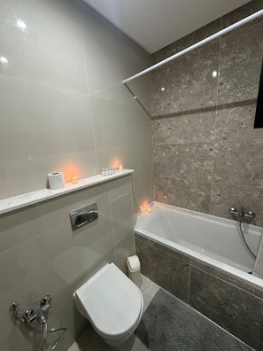 A modern bathroom with a bathtub, toilet, and vanity. - Exceptional Apartment Luxury and Absolute Comfort (Tunis)