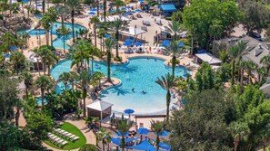 Un resort con varias piscinas, palmeras y tumbonas.