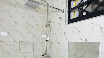 A bathroom with a shower, a sink, and a mirror.