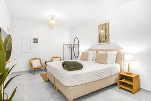 A bedroom with a bed, bedside table, lamp, wall art, and a mirror. - Studio Mei Mei – studio within walking distance of Jan Thiel (Jan Thiel)
