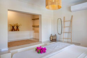 A bedroom with a bed, a hanging light fixture, a mirror, and a ladder. - Casa Abou........... (Jan Thiel)