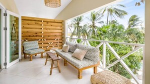 A balcony with a wooden wall, two patterned sofas, a bench, and a hanging light fixture. - Cas Agave 2bedroom apartment with swimming pool in Jan Thiel (Jan Thiel)