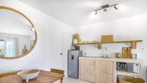 A compact kitchen with a wooden dining table, a refrigerator, and a microwave. - Cas Agave 2bedroom apartment with swimming pool in Jan Thiel (Jan Thiel)