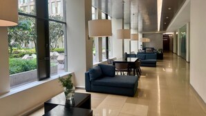 Eine moderne Hotelhalle mit einer langen Korridor, Sitzbereichen und großen Fenstern.
