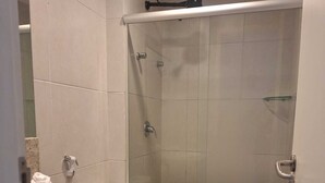 Une salle de bain avec douche, toilettes et lavabo.